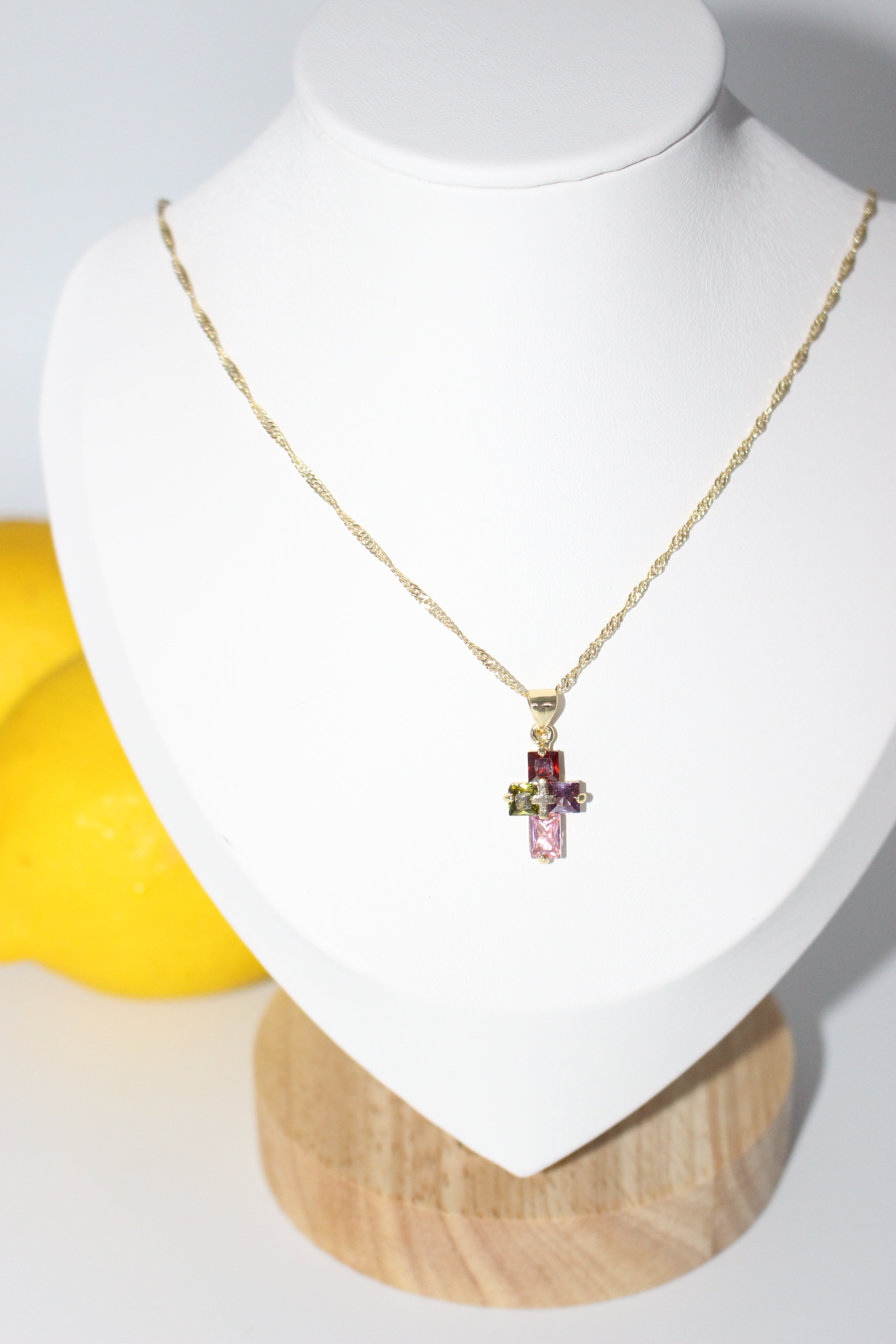 Necklace with a pendant on a white stand with a yellow object in the background