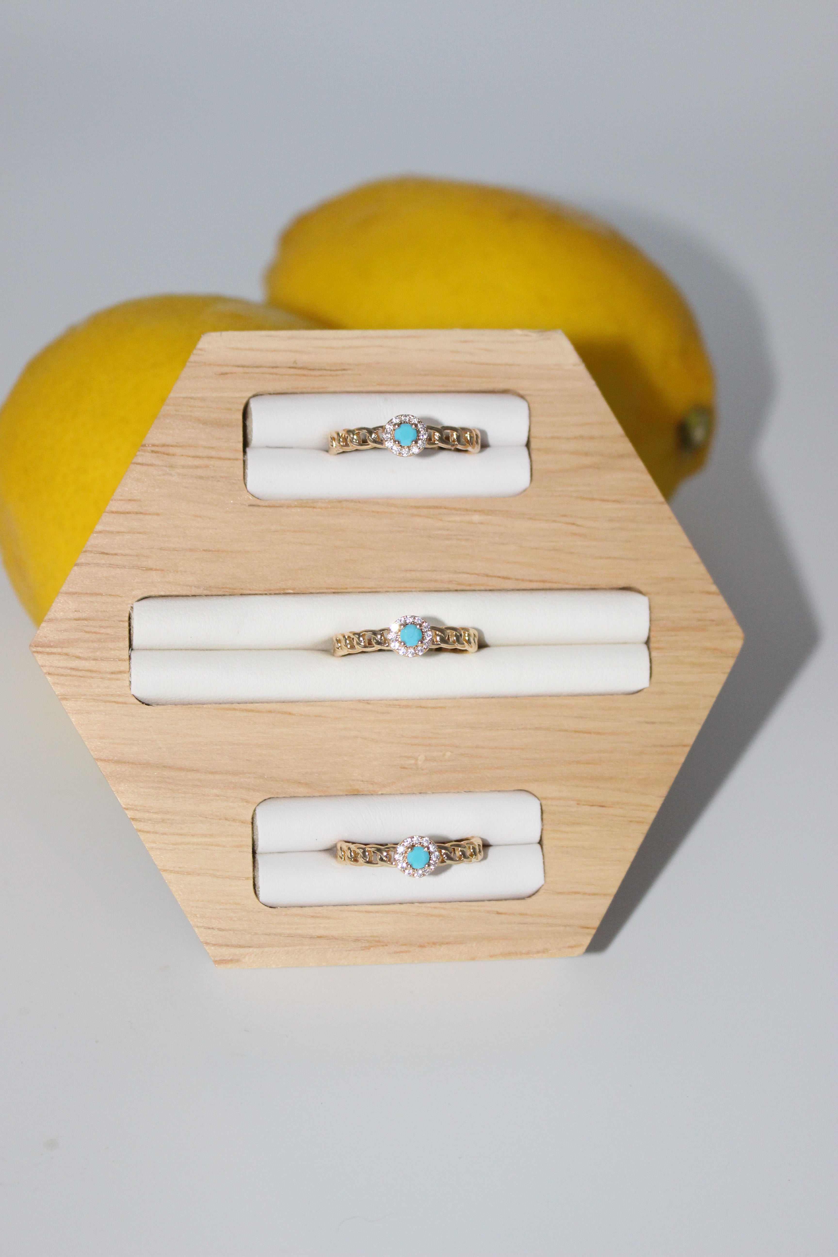 Jewelry display with rings on a wooden stand against a light gray background