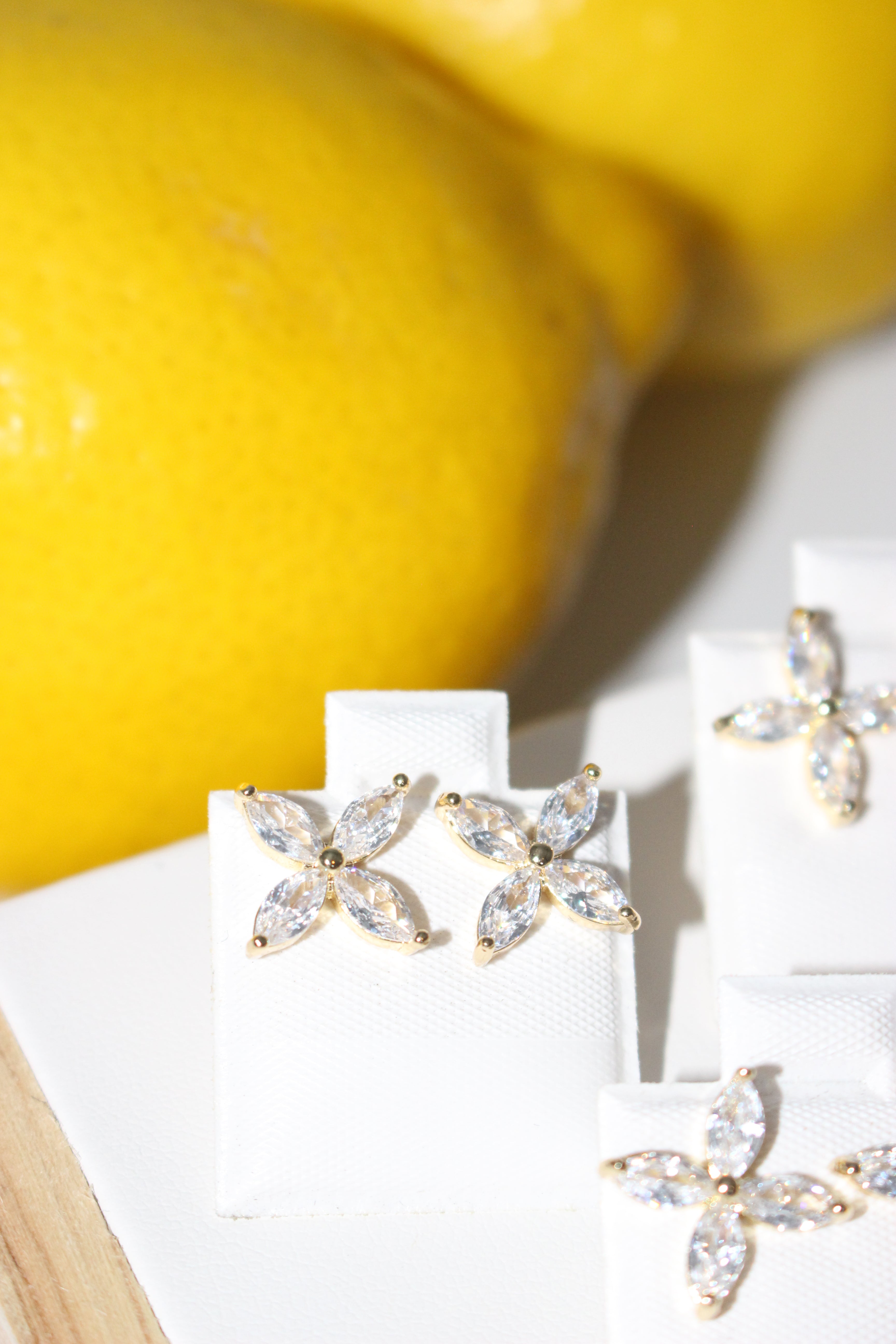 Flower-shaped earrings on a white card with a yellow background
