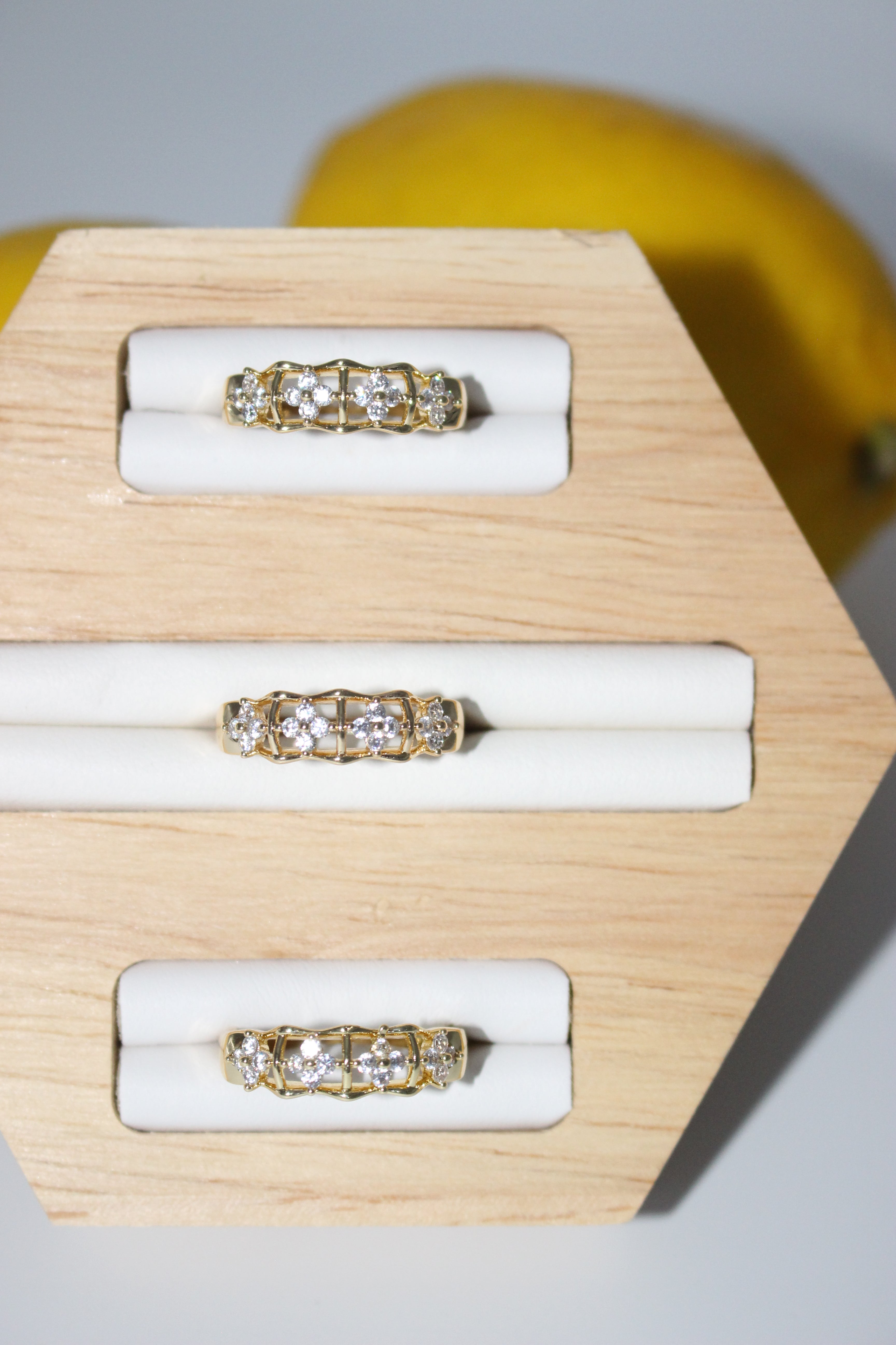 Gold and diamond rings on a wooden display block.
