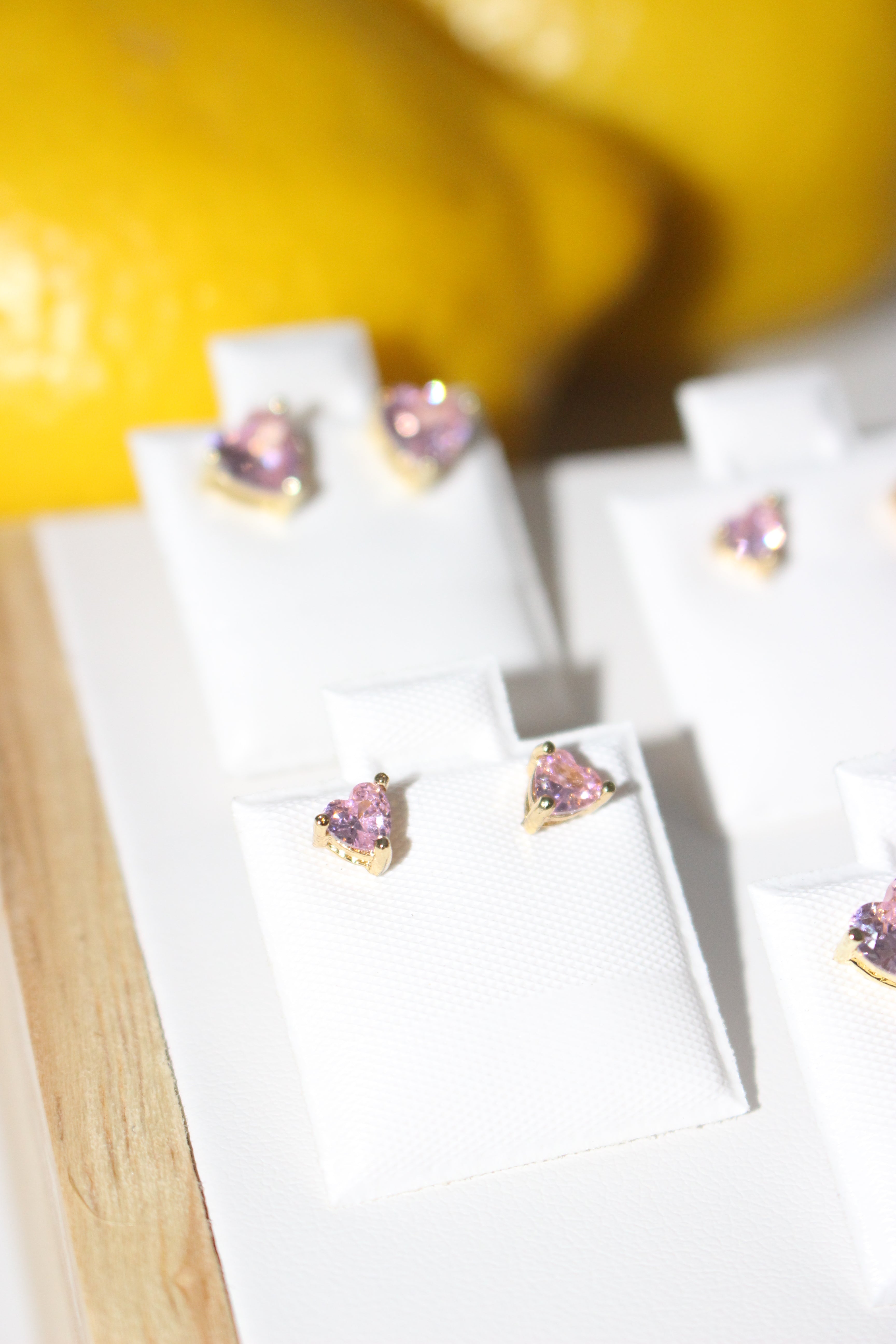 Pair of earrings with pink gemstones on a white surface.
